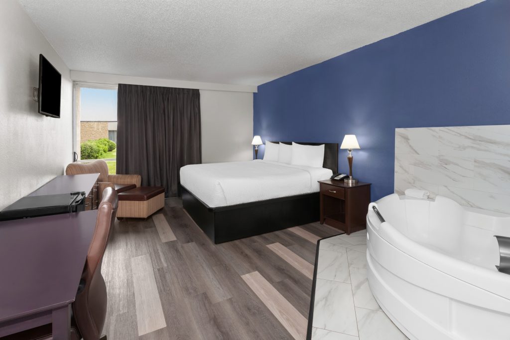 King bed and in-room whirlpool tub in the deluxe studio suite at Travelodge by Wyndham Milwaukee